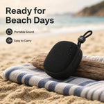 AEMAI mini portable speaker ready for beach days on sand towel with ocean background waterproof outdoor use